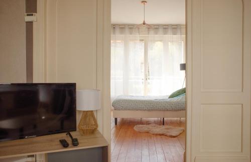 a living room with a bed and a television at Spa , jardin 250m2 et appartement cosy de 60 m2 au centre in Boulogne-sur-Mer