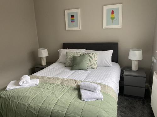 a bedroom with a large bed with towels on it at Modern 1 BDR City apartments by Belfast City Breaks in Belfast