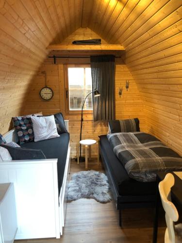 ein Wohnzimmer mit einem Sofa und einem Bett in der Unterkunft Bezauberndes Gartentiny in Steffisburg