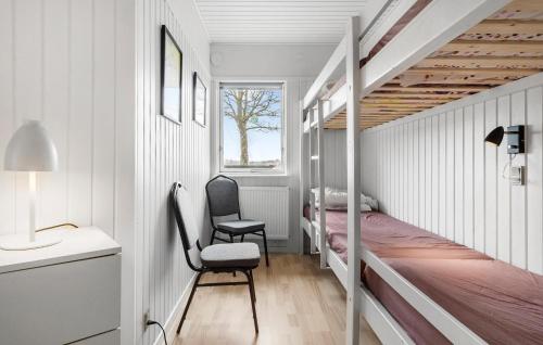 Dormitorio pequeño con litera y silla en Pet Friendly Home In Sams With Kitchen en Ballen