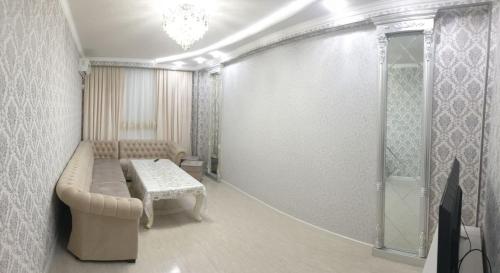 sala de estar con sofá y mesa en Апартамент в элитном районе, en Andiján