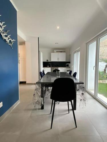 une salle à manger avec une table et des chaises en verre dans l'établissement Rez de jardin vue mer, à Marseille