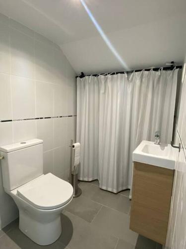 une salle de bain avec des toilettes blanches et un lavabo dans l'établissement Rez de jardin vue mer, à Marseille