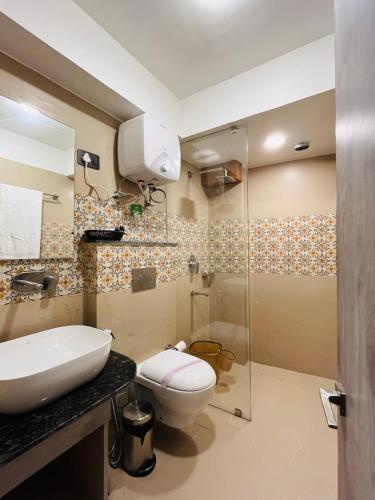 W łazience znajduje się toaleta i przeszklony prysznic. w obiekcie Goroomgo Broadway Boutique Mall Road Darjeeling - Luxury Stay - Best Seller w mieście Dardżyling