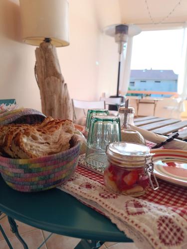 a table with a bowl of bread and a jar of jam at Il Sentiero B&Bìo in SantʼAntìoco