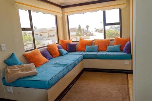 a large blue couch sitting in front of a window at Palazzo Gardens -Self catering Guesthouse in Swakopmund