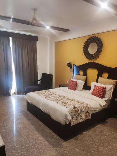 a bedroom with a large bed and a mirror at Aloha Apartments by blissful Ganges in Rishīkesh