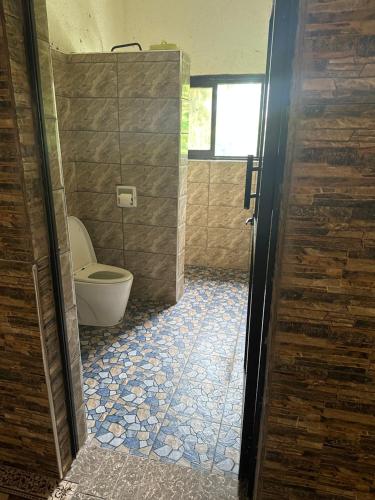 a bathroom with a toilet and a window and a doorway at Heidi’s Beach Stay in Mombasa