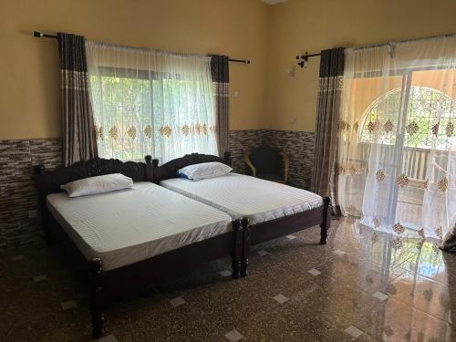 a bed in a bedroom with curtains and a window at Heidi’s Beach Stay in Mombasa