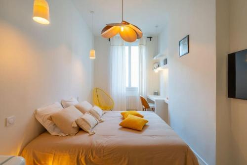 une chambre avec un lit avec des oreillers jaunes dessus dans l'établissement Le St Victor, garage privé, 1 minute du Vieux Port, à Marseille
