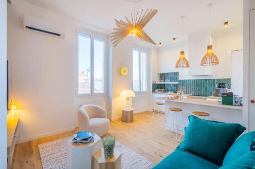 un salon avec un canapé bleu et une cuisine dans l'établissement Le St Victor, garage privé, 1 minute du Vieux Port, à Marseille