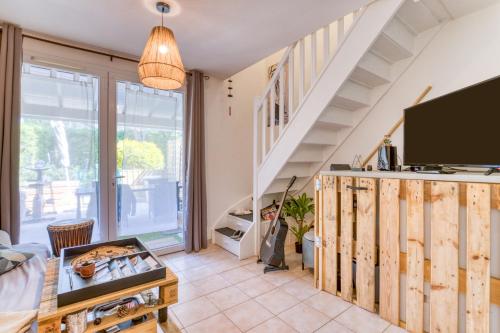 a living room with a tv and a staircase at Maison - Residence avec piscine in Calvisson