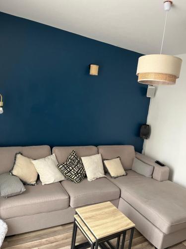ein Wohnzimmer mit einem Sofa und einer blauen Wand in der Unterkunft Entre Lac et Mer in Clermont-lʼHérault