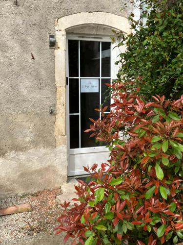 a door in a building with a bush in front of it at Le temps retrouvé in Rouvres-la-Chétive