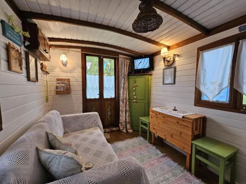 a living room with a couch and a table at Roulotte Fleur des Champs in Sigalens