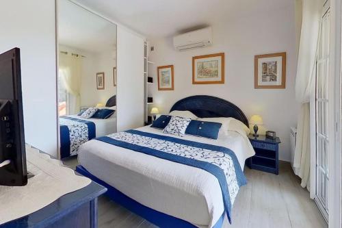 une chambre avec deux lits et un grand miroir dans l'établissement Les issambres vue mer, à Roquebrune-sur Argens