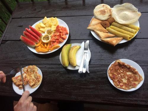 uma mesa de madeira com pratos de comida para o pequeno-almoço em AMRON RESORT SIGIRIYA em Sigiriya