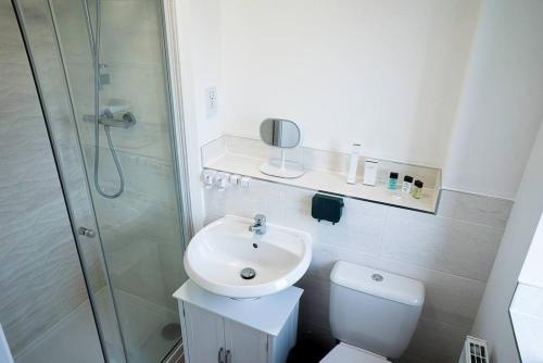 彼得伯勒的住宿－Idyllic 3-bed home with Parking in Peterborough by HP Accommodation，浴室配有卫生间、盥洗盆和淋浴。