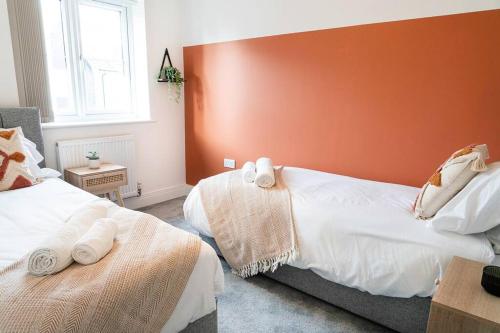 彼得伯勒的住宿－Idyllic 3-bed home with Parking in Peterborough by HP Accommodation，一间卧室配有两张带毛巾的床