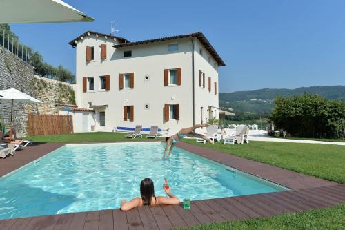 a person jumping into a swimming pool in a house at Villa Allegri Agriturismo di Charme in Negrar