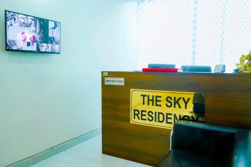 a desk with a sign that reads the sky requested now at Hotel Inn sky in New Delhi