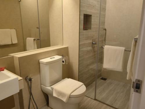 a bathroom with a toilet and a glass shower at Windmill Upon Hills Premium Suite By Rapi Stay in Genting Highlands