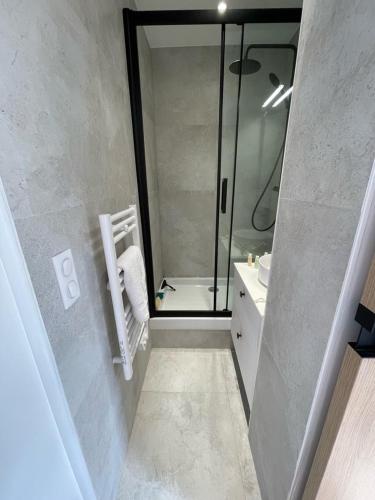 uma casa de banho com uma cabina de duche em vidro e um lavatório. em Hipster Paris North em Paris