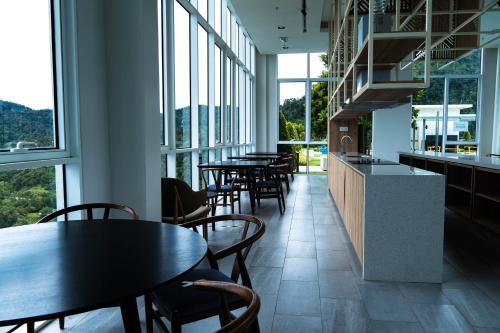 a row of tables and chairs in a room with windows at Windmill Upon Hills Premium Suite By Rapi Stay in Genting Highlands