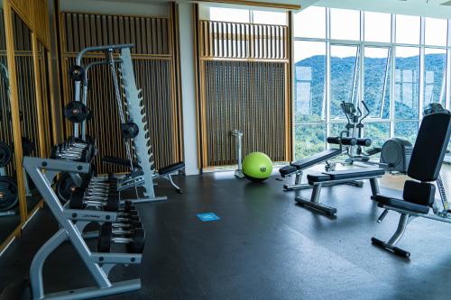 a gym with treadmills and exercise equipment and windows at Windmill Upon Hills Premium Suite By Rapi Stay in Genting Highlands