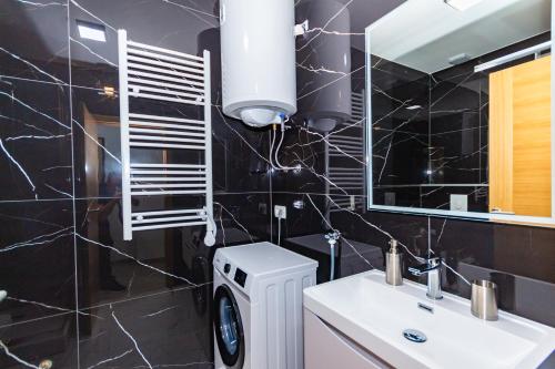 a bathroom with a white sink and a mirror at Apartman Krželj A2 in Livno