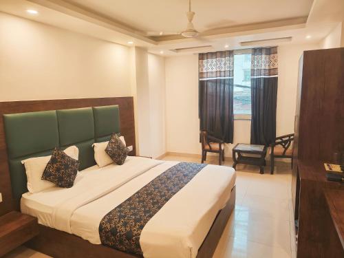a bedroom with a bed and a desk and a window at Hotel D Tark Near IGI Airport in New Delhi