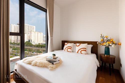 sypialnia z łóżkiem i dużym oknem w obiekcie Exclusive D1mension in District 1 3BR Apartment FreePoolSaunaGym w Ho Chi Minh