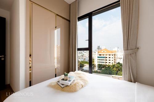 sypialnia z łóżkiem i dużym oknem w obiekcie Exclusive D1mension in District 1 3BR Apartment FreePoolSaunaGym w Ho Chi Minh