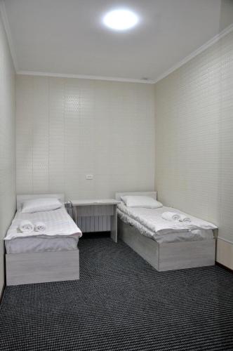 a room with two beds and a table in it at Bilol Guest House in Samarkand
