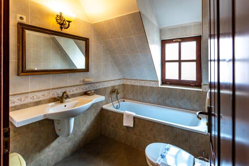 a bathroom with a sink and a tub and a mirror at Hotel Casa Wagner in Sighişoara