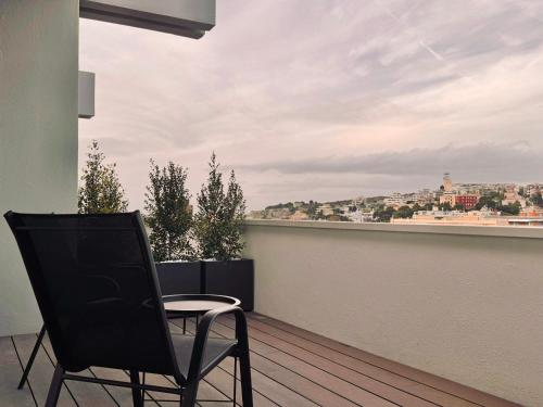a chair on a balcony with a view of a city at Mameli View Cagliari in Cagliari