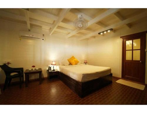 a bedroom with a bed and a table with a chair at Anantra Sea View Resort, Agonda, Goa in Agonda