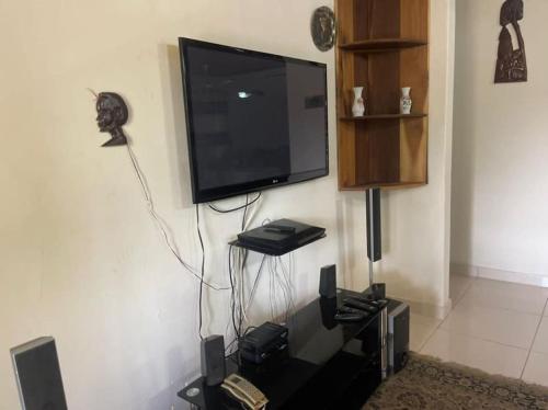 a flat screen tv hanging on a wall at Naturally green and eco friendly 4 bedroom ensuite(Badoo' Parliament) in East Legon