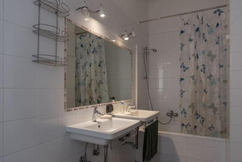 a bathroom with two sinks and a mirror and a shower at Gibilmanna Home in Rome