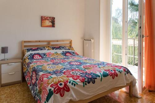 a bedroom with a bed with a colorful comforter at Gibilmanna Home in Rome