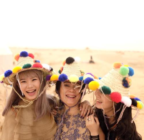 two girls wearing straw hats on the beach at Luxury Bedouin Camp in Merzouga
