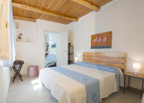 a bedroom with a bed and a table and a chair at Dimora Mare in San Teodoro
