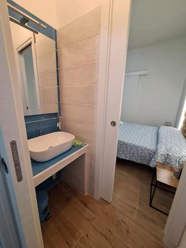 a small bathroom with a sink and a bed at Dommu Amsicora in Baunei