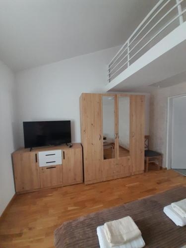 a room with a bed and a tv on a wooden cabinet at Nemanjina Centar in Pančevo