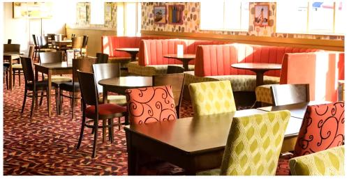 a dining room with tables and chairs and tables and chairs at HARTS Holiday Park Home in Leysdown-on-Sea