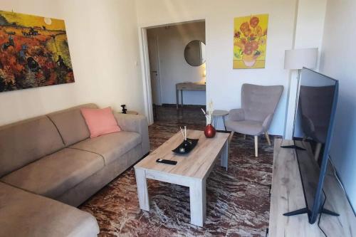 - un salon avec un canapé et une télévision dans l'établissement Comfort apartment in the city, à Kalamata