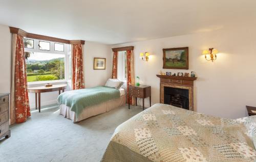 a bedroom with two beds and a fireplace at Chapel Knap Porlock Weir in Porlock