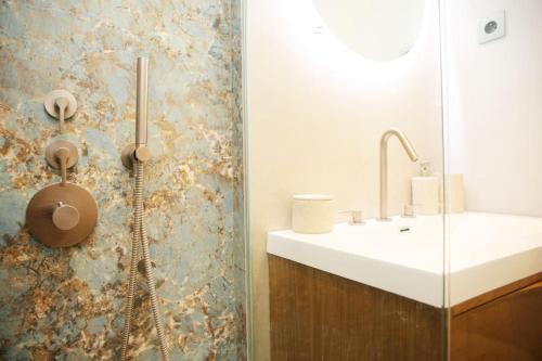une salle de bain avec un lavabo et une douche dans l'établissement Expérience parisienne en plein coeur du marais, à Paris