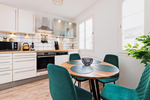 a kitchen with a wooden table and green chairs at Perfect for 6 guests Kitchen Parking Netflix in Wuppertal