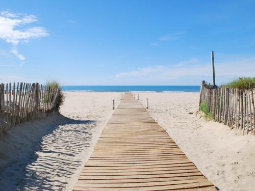 a wooden path to the beach with the ocean in the background at Rare Loft vue sur les toits - Suites Gaya Centre Historique in Montpellier